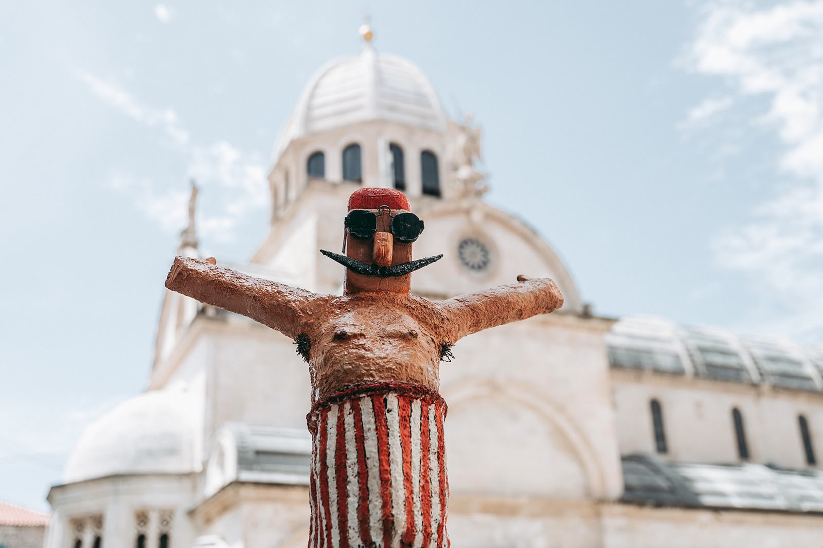 A playful handmade swimmer sculpture displayed in front of the Cathedral of St. James