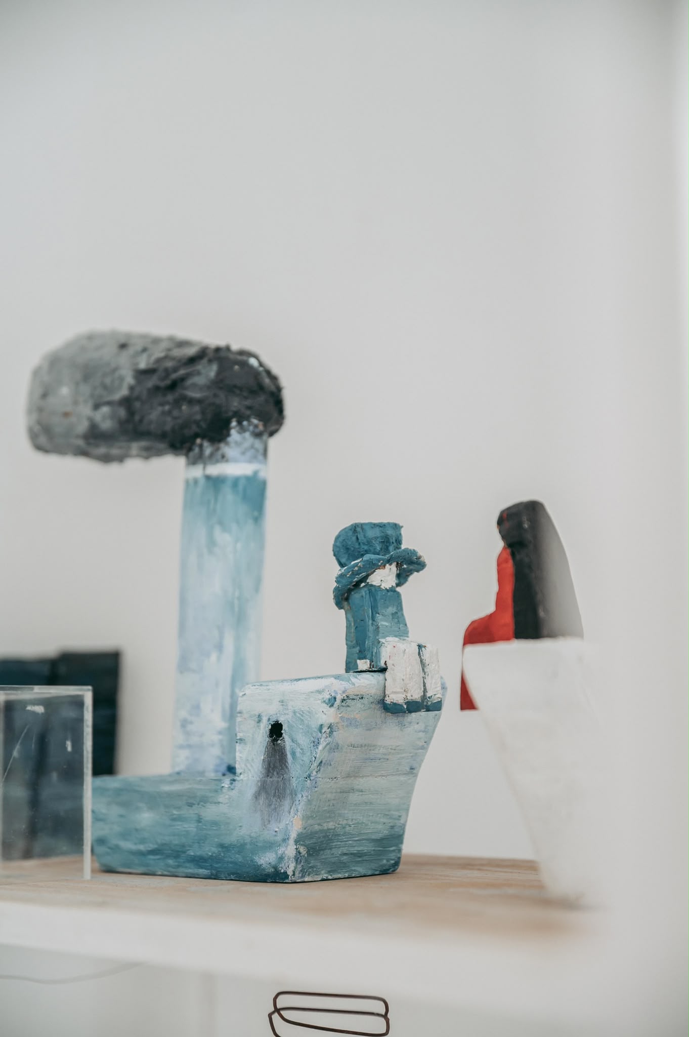 Two painted figurative sculptures displayed by an open window overlooking Šibenik