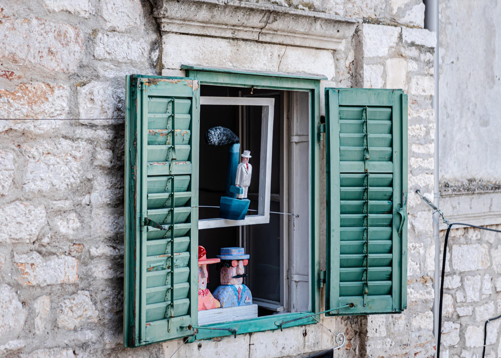 A handmade angel sculpture photographed against the Cathedral of St. James in Šibenik
